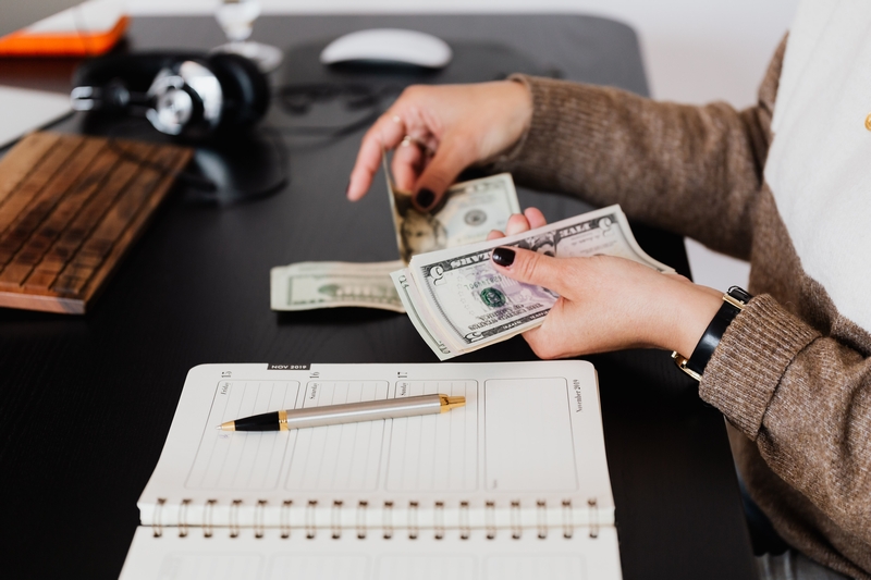 businesswoman-counting-money-while-sitting-at-desk